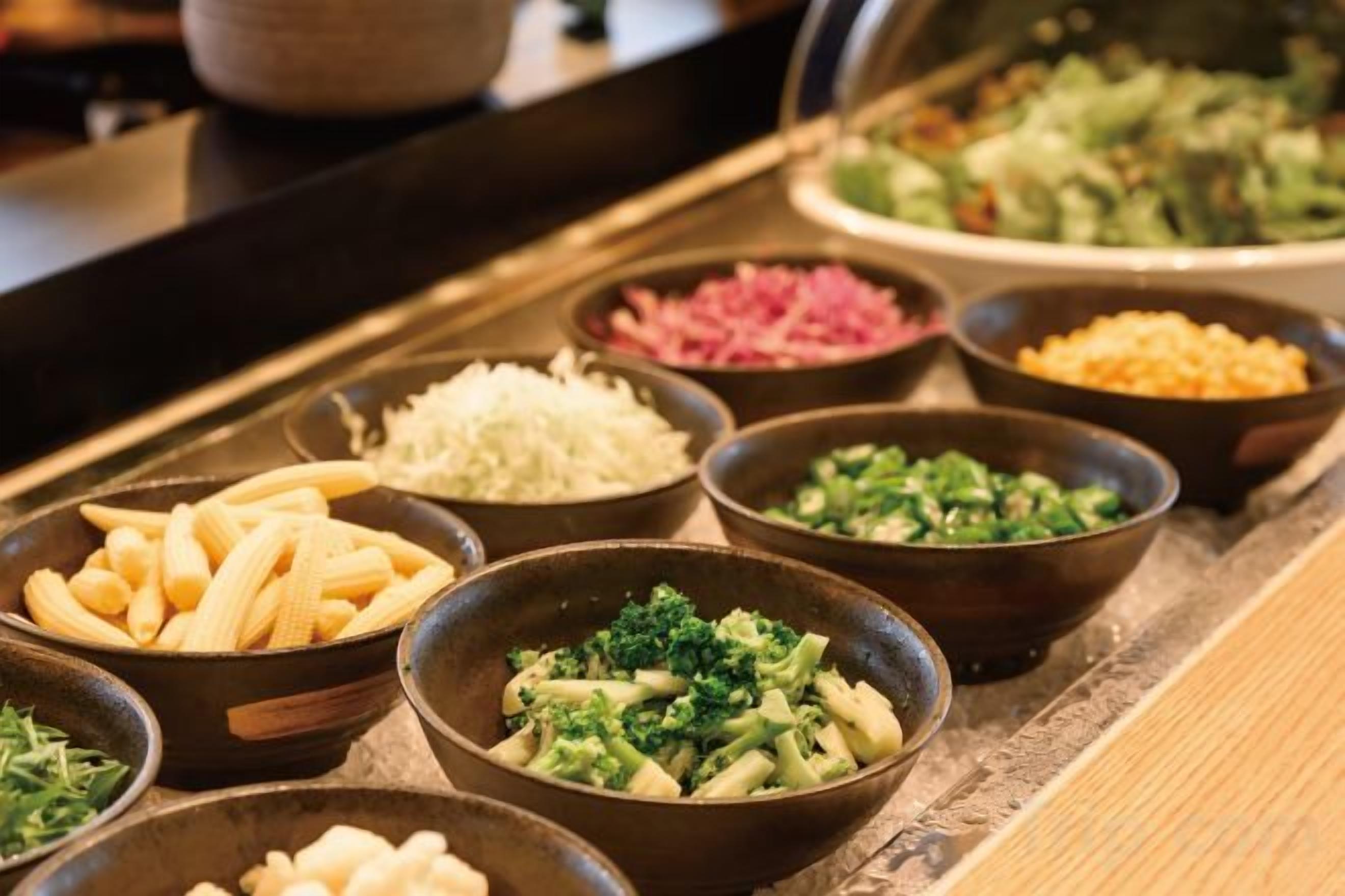 A buffet with various food items in bowls.