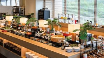 A buffet setup with various food items, plates, and serving utensils.