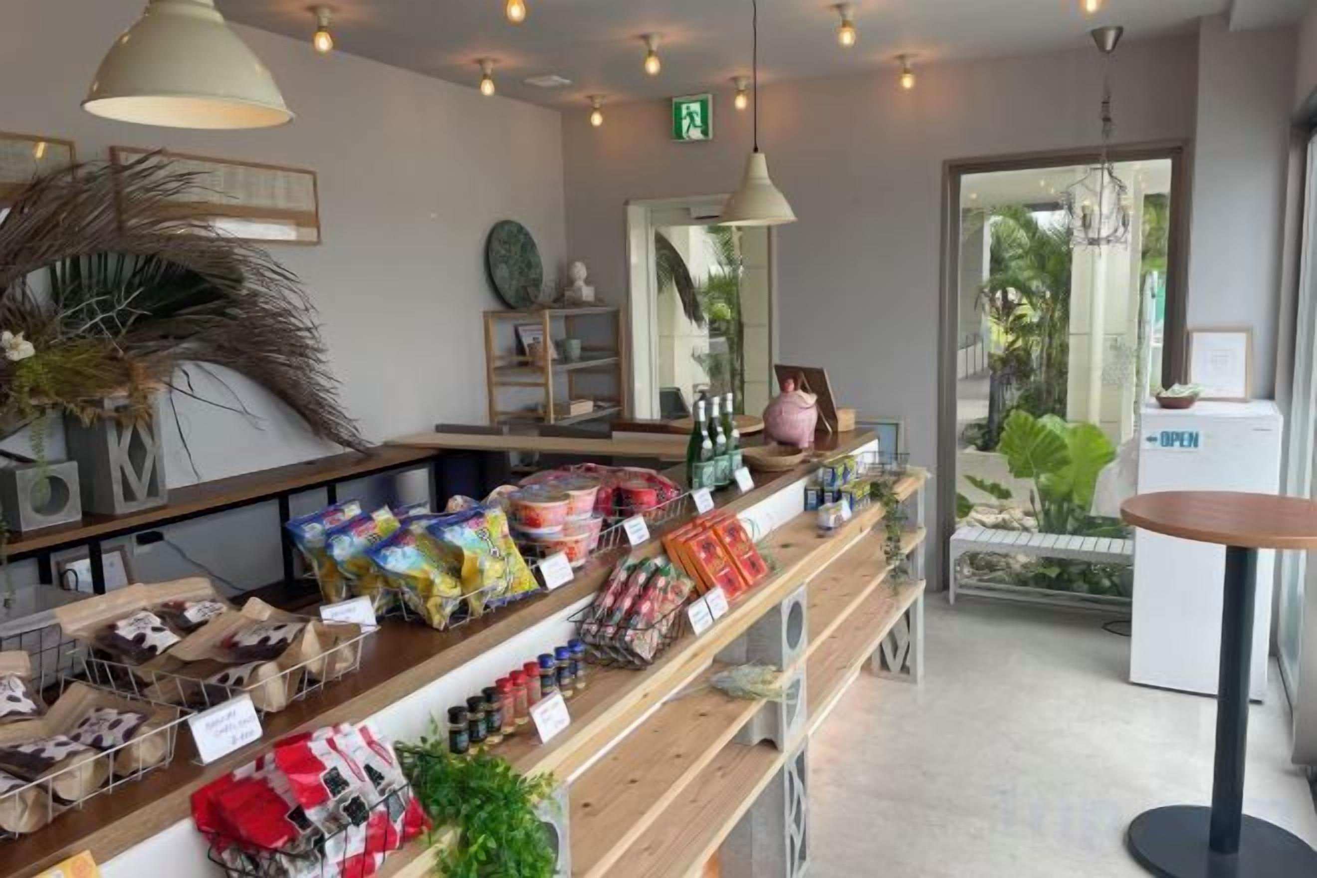 A store interior with shelves stocked with various products, a counter with items for sale, and a door leading outside.