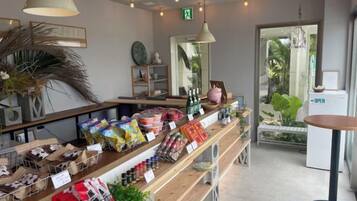 A store interior with shelves stocked with various products, a counter with items for sale, and a door leading outside.