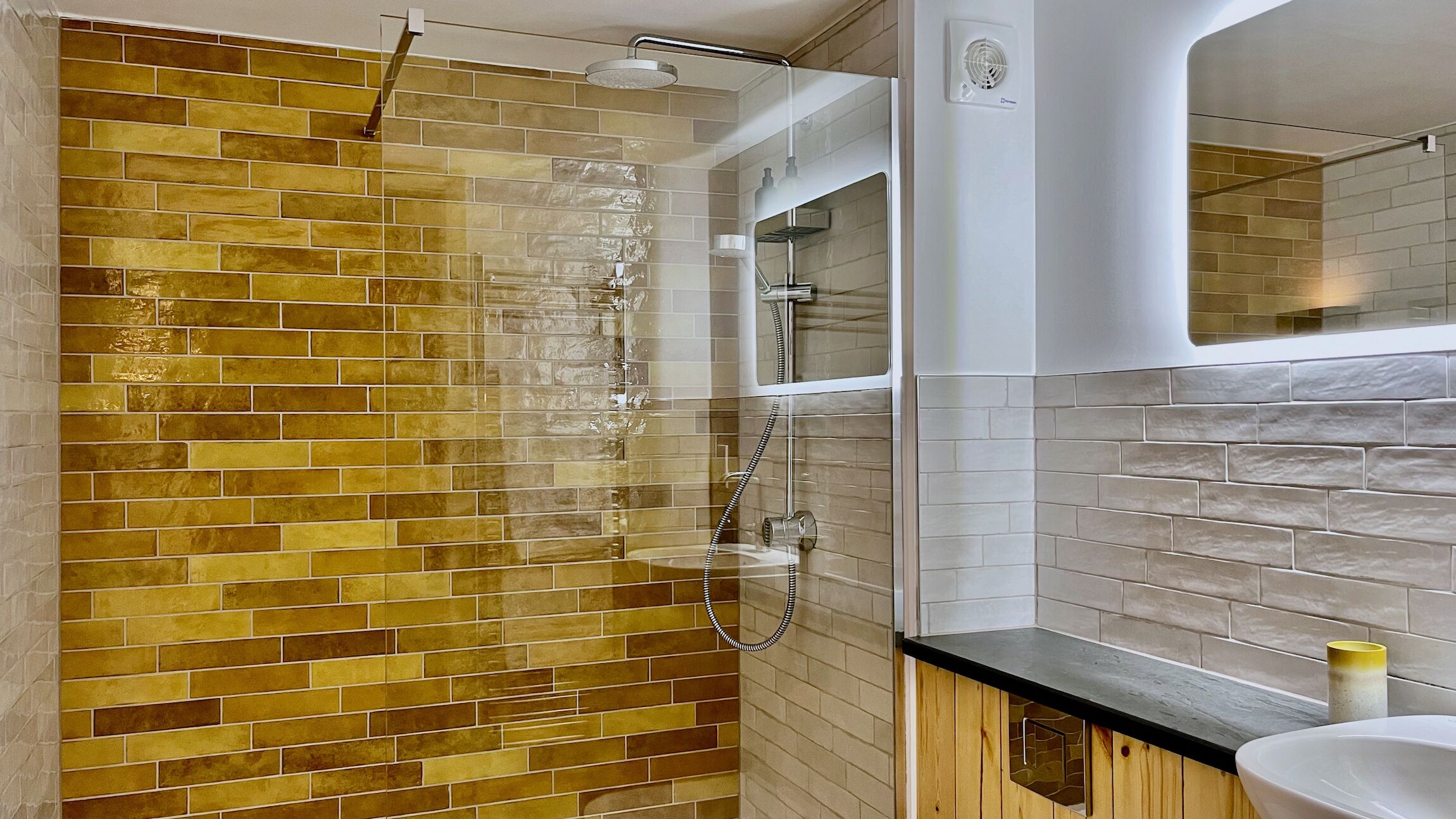 A bathroom with a shower, a sink, and a mirror.