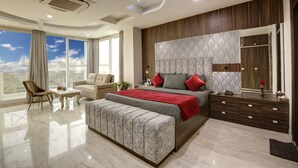 A modern bedroom with a large bed, a seating area, and a view of the sky. - SONESTA LUXURY APARTMENT (New Delhi)