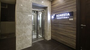 A reception area with a sign reading "SONESTA RECEPTION" and a modern elevator. - SONESTA LUXURY APARTMENT (New Delhi)