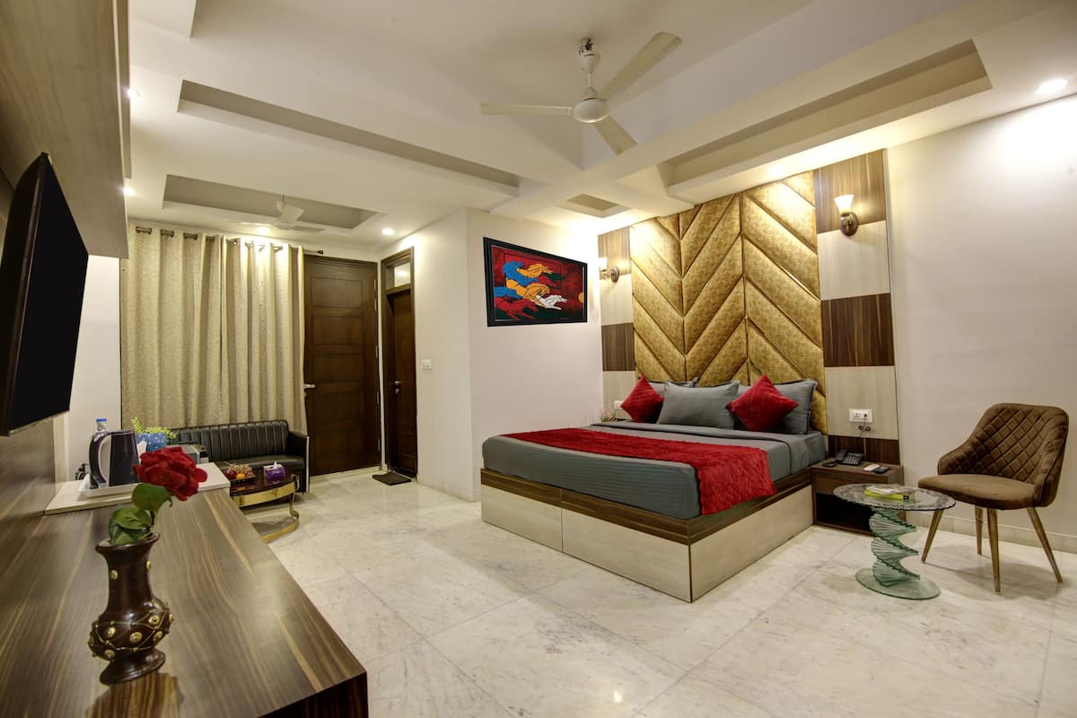 A modern bedroom with a bed, a sofa, a glass coffee table, and a chair.