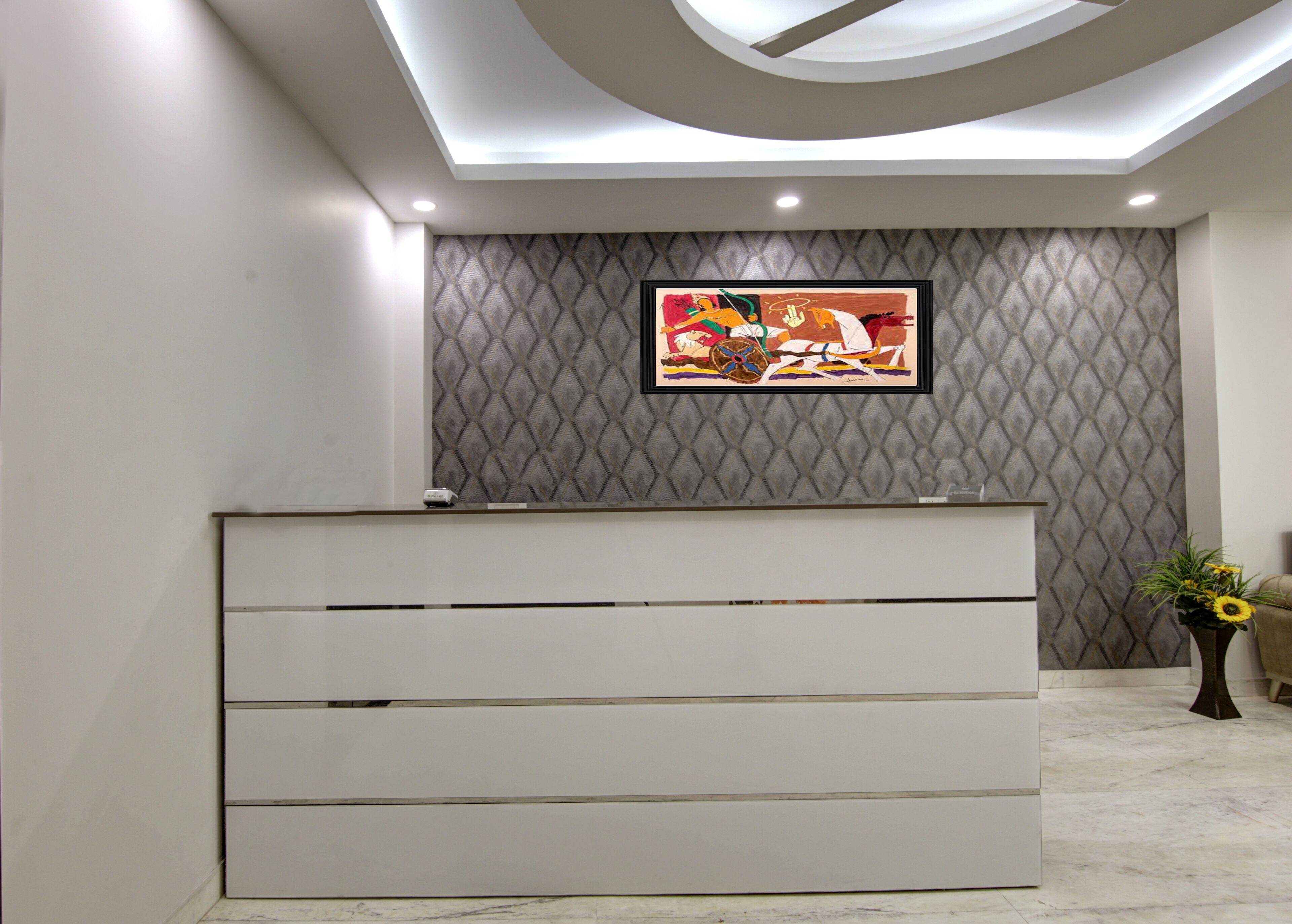 Un mostrador de recepción de diseño moderno, una pared con un diseño y una obra enmarcada encima.