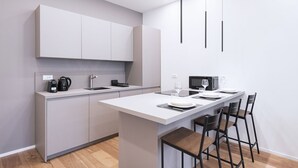 Une cuisine moderne dotée d’un îlot central, de tabourets de bar et d’un coin repas.