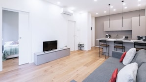 Un appartement moderne comprenant un espace de vie, une kitchenette et une chambre.