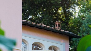 Un bâtiment à la façade rose, aux fenêtres blanches et surmonté d’une lanterne.