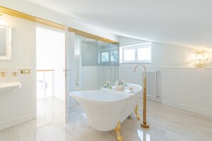Een aparte badkuip en douche, designer toiletartikelen, een haardroger