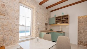 A kitchen with stone walls, a window, and a view of the sea. - Nice home in Dobrince (Dobrince)