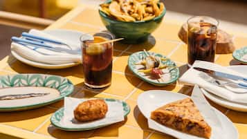 A table with food items, drinks, and cutlery.