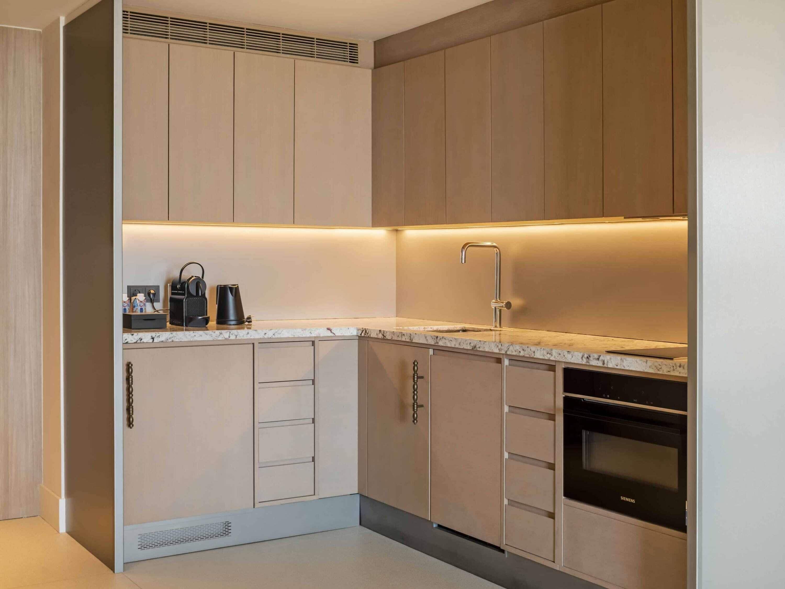 A modern kitchen with built-in appliances, a sink, and a Siemens oven.