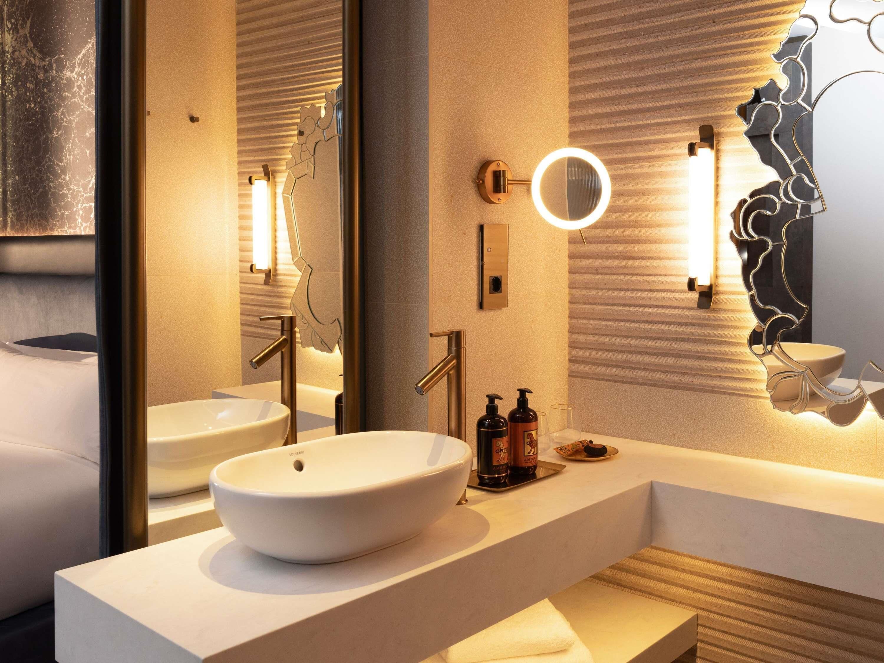 Un baño moderno con un espejo grande, dos lavamanos y tocador.