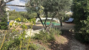 Ett poolområde med solstolar och en pergola.