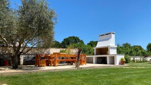 A modern house with a white exterior, a large lawn, and a wooden bench area. - Modern Studio apartment "Zara" with private balcony, shared pool (Pula)