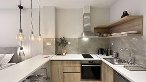Una cocina moderna con horno empotrado, lavavajillas y encimera de madera.