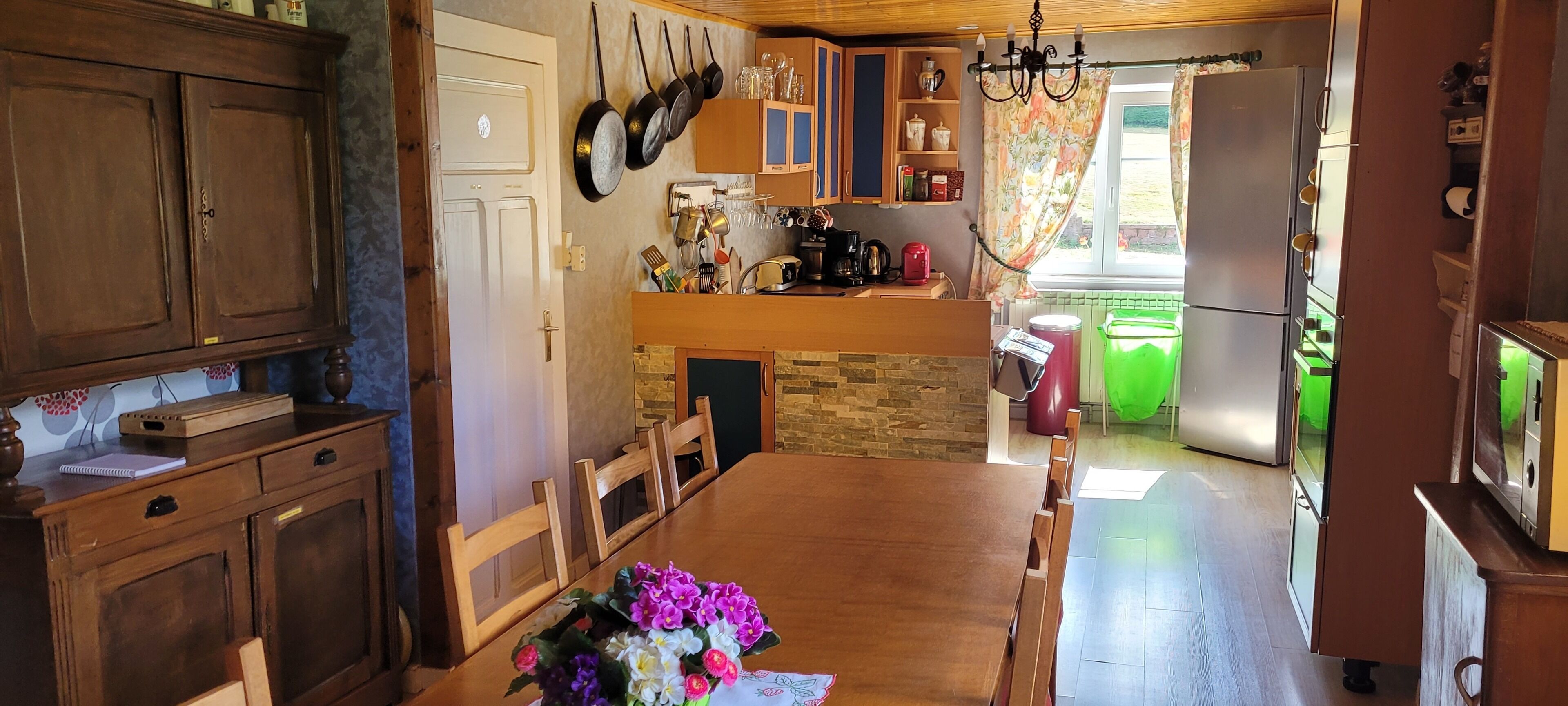 Una cocina con armarios de madera, encimera de piedra y una mesa de comedor con sillas.