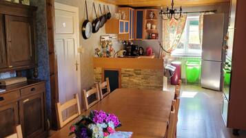 Una cocina con armarios de madera, encimera de piedra y una mesa de comedor con sillas.