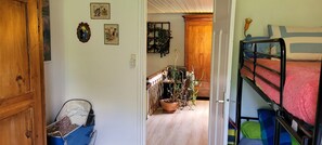A room with a bunk bed, a wooden door, a small desk with a chair, and a potted plant. - Gîte Forestier du Moulin (Raon-sur-Plaine)