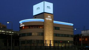 A modern hotel with a prominent 'm' logo on the facade, multiple floors, and a curved design. - HOTELm - Adults Only (Matsudo)