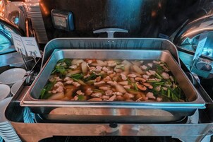Un bufé con diversos platos, incluyendo carne y verduras.