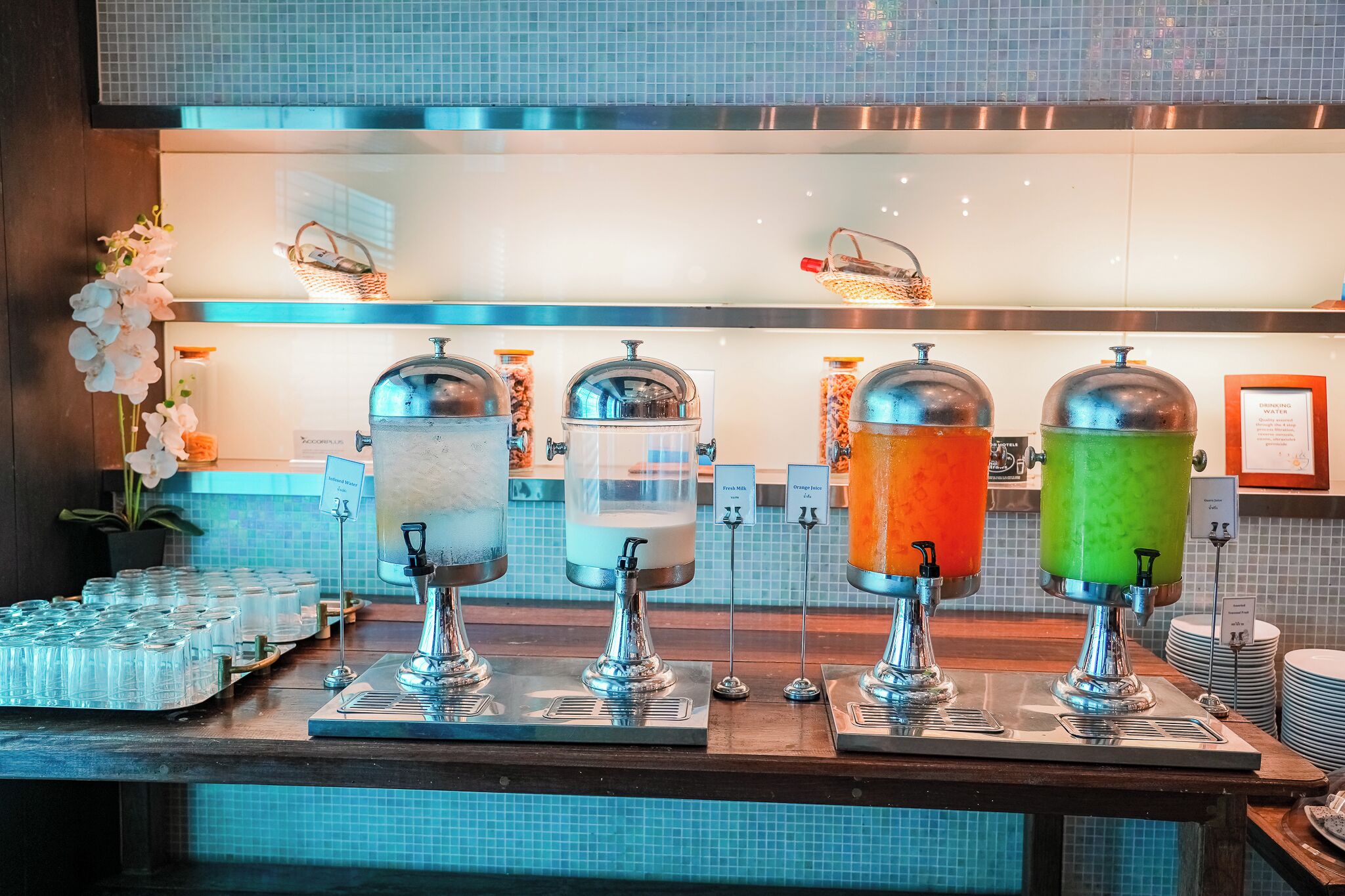 A beverage station with four dispensers, each labeled with a different drink.
