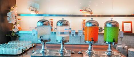 A beverage station with four dispensers, each labeled with a different drink.