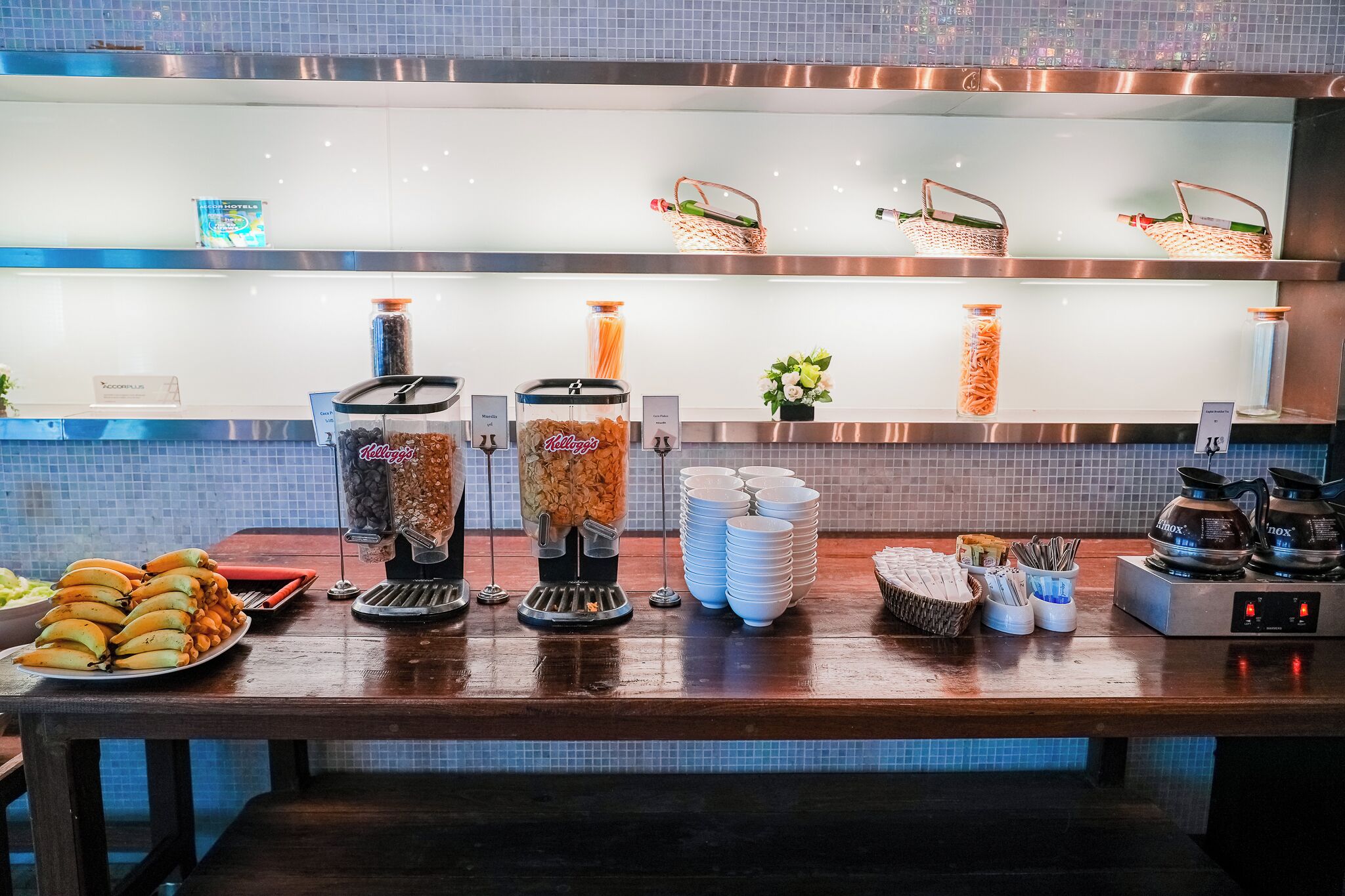 A buffet area with various food items and condiments.