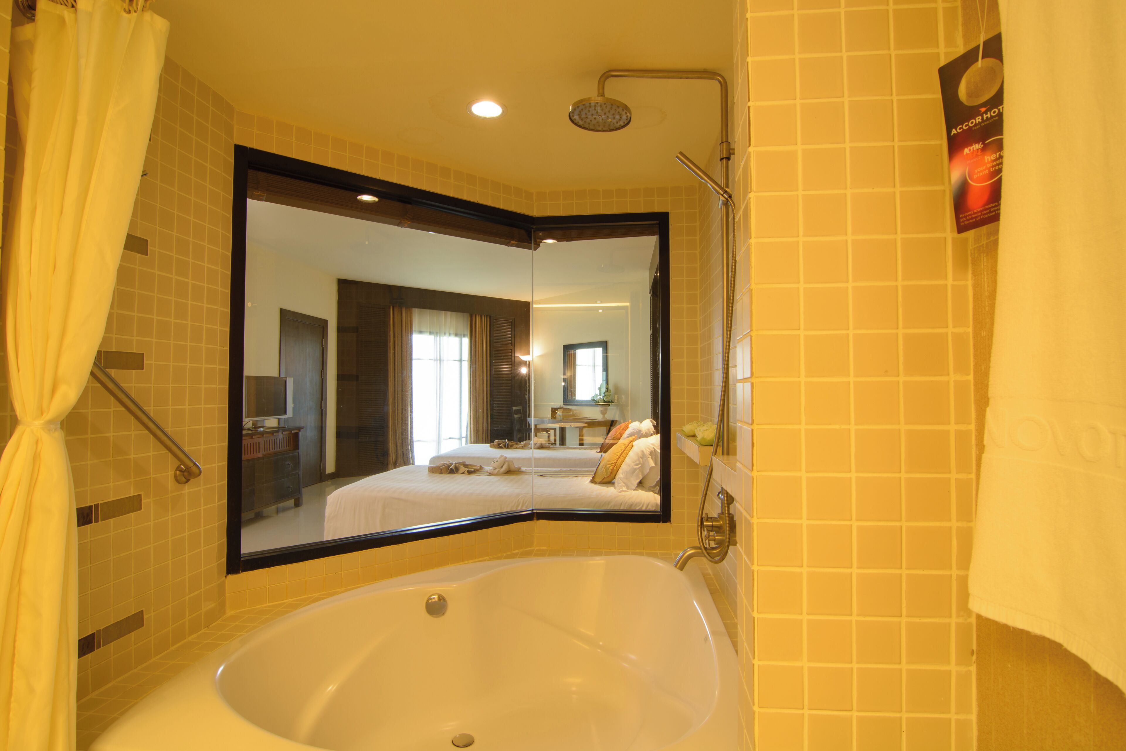 A bathroom with a large mirror, a bathtub, and a shower.
