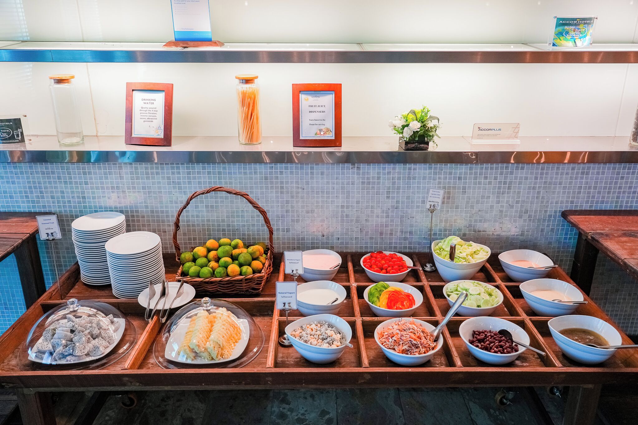 A buffet area with various food items and condiments.
