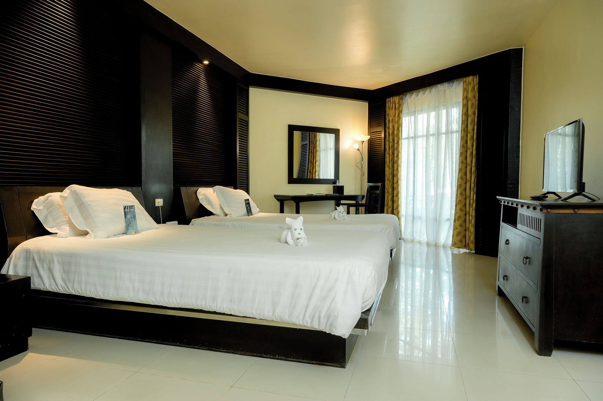 Una habitación de hotel con una cama grande, un escritorio, un tocador y un espejo.