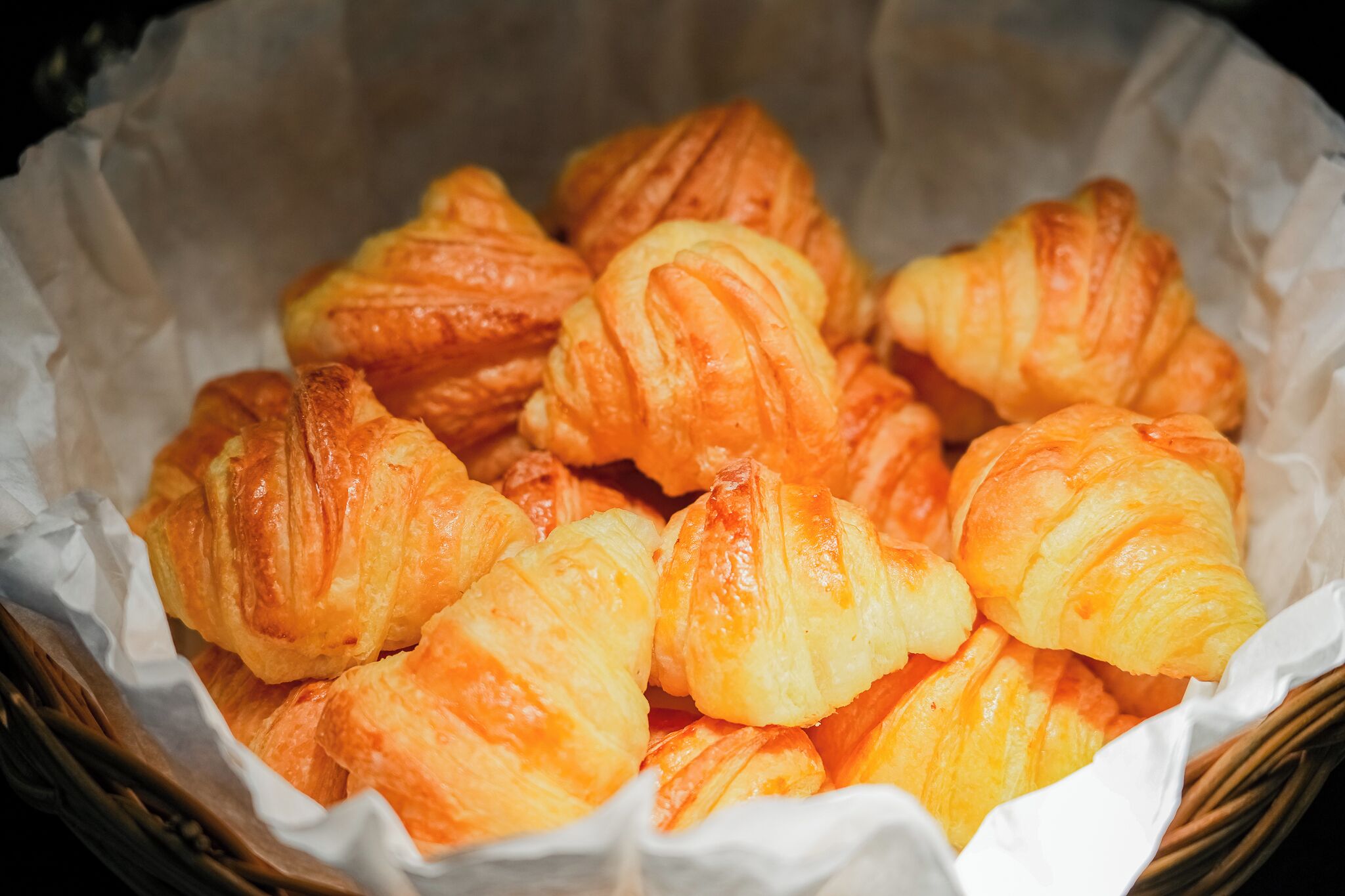 A basket of golden-brown croissants.