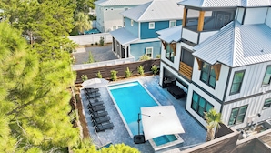 A modern residential area with a swimming pool, lounge chairs, and a barbecue area. - Diamond Oasis | Private Pool/Spa | Arcade Games | Private Beach Access (Miramar Beach)