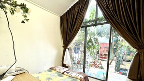 A room with a bed, a desk, and a window with curtains. - Lake View Homestay (Dien Hong)