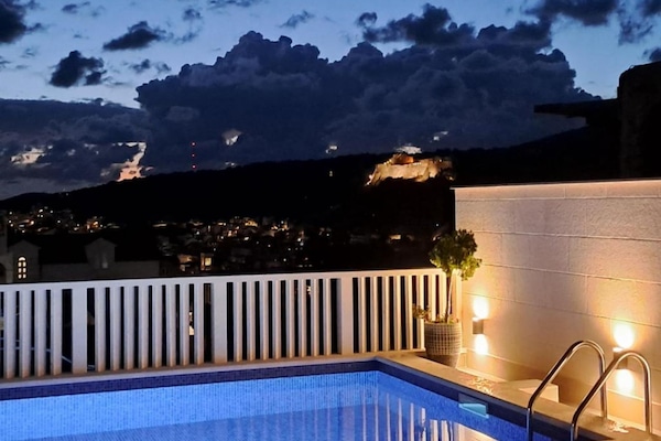 Una piscina al aire libre de temporada, sombrillas