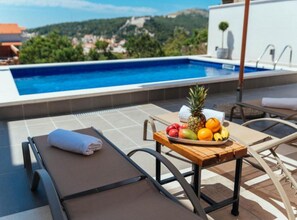 Una piscina al aire libre de temporada, sombrillas, tumbonas