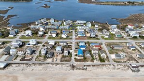 Luchtbeeld van een kustgebied met woonhuizen, wegen en een strand.