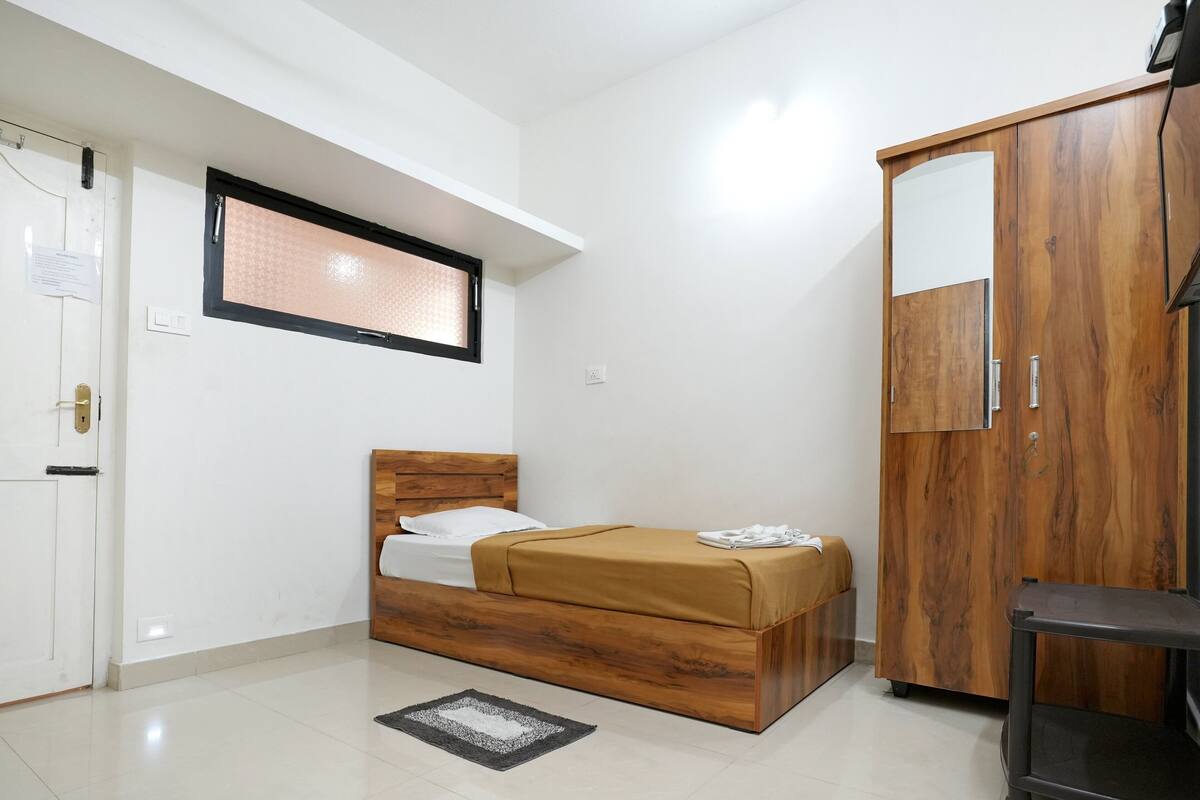 A bedroom with a wooden bed, a wardrobe, and a small table.