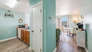 Een ruimtelijk ingerichte leefruimte met kitchenette, eethoek en uitzicht op de omgeving.