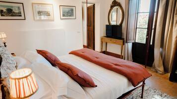 A bedroom with a bed, a bedside table, a lamp, and a mirror.