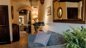 Un salon chaleureux avec un canapé gris, une lampe verte et un grand miroir.