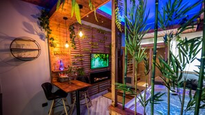 Una habitación acogedora con pared de madera, televisión, chimenea y comedor con sillas.