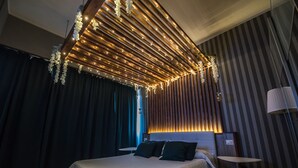 Un dormitorio moderno con una cama, una mesita de noche y una lámpara fijada a la pared.