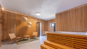 Un intérieur moderne avec des murs lambrés en bois, une table de billard et deux fauteuils en osier.