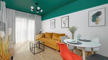 Ein modernes Wohnzimmer mit einer Couch, einem Esstisch, Stühlen und Kunstwerken an den Wänden.