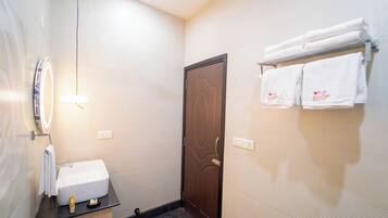 Un bagno con lavandino, specchio, porta asciugamani e porta.