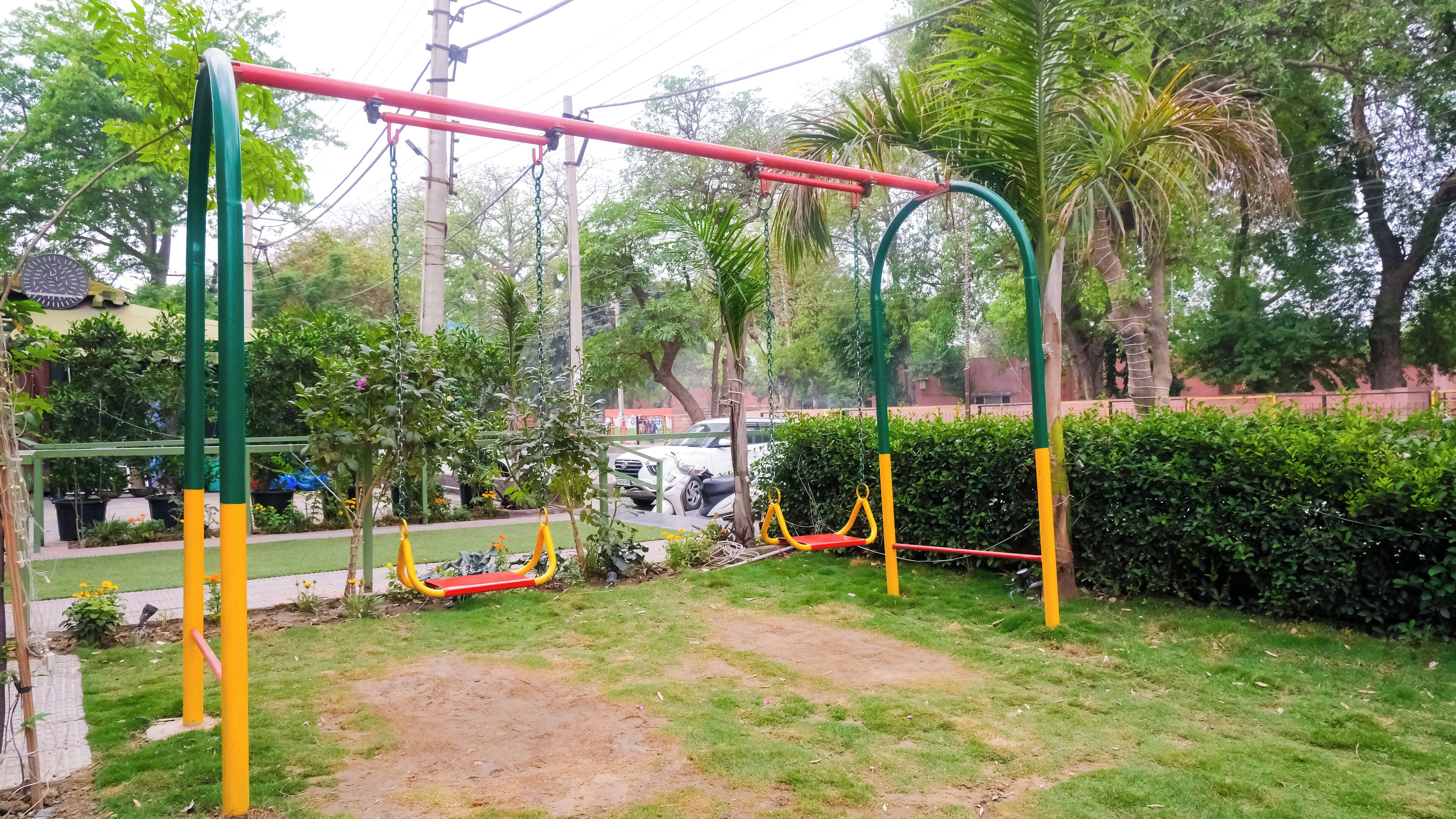 A playground with swings and a red and yellow slide.