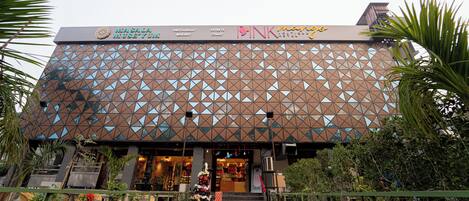 A building with a geometric facade, a staircase leading to the entrance, and a small Christmas tree.