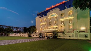 Een groot, goed verlicht hotel met een opvallend bord waarop 'Omni Residency' staat.