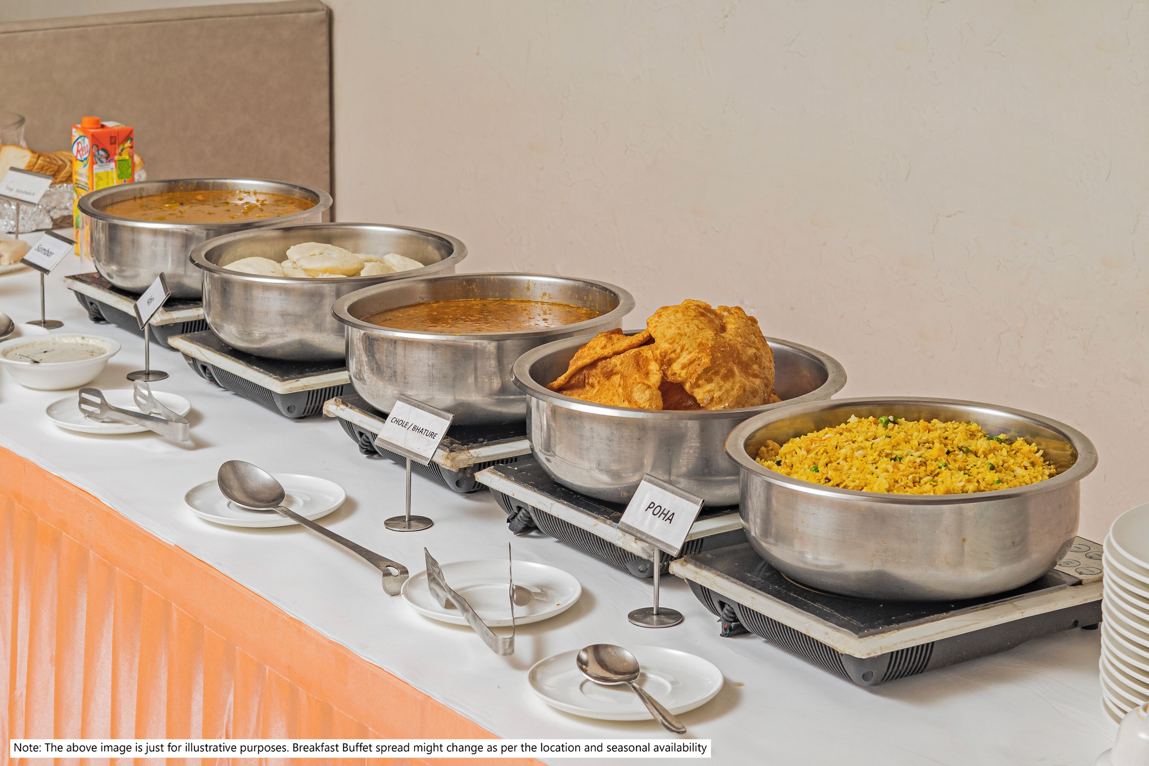 Un buffet proposant différents plats, chacun étant clairement identifié, notamment les plats appelés « POHA » et « CHOLI ».